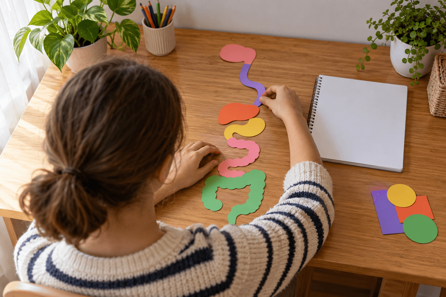 Elev văzut din spate, aranjând forme colorate fără inscripții pentru a studia sistemul digestiv