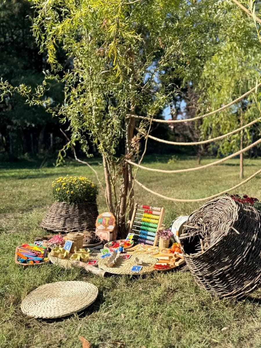 Sală luminoasă de grădiniță cu materiale educaționale pe mese